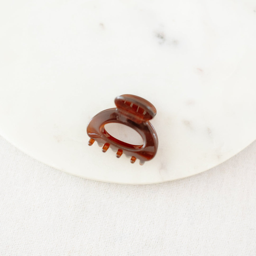 Brown hair clip on a white marble surface