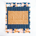 Fabric square with blue, orange, and floral patterns on a white background