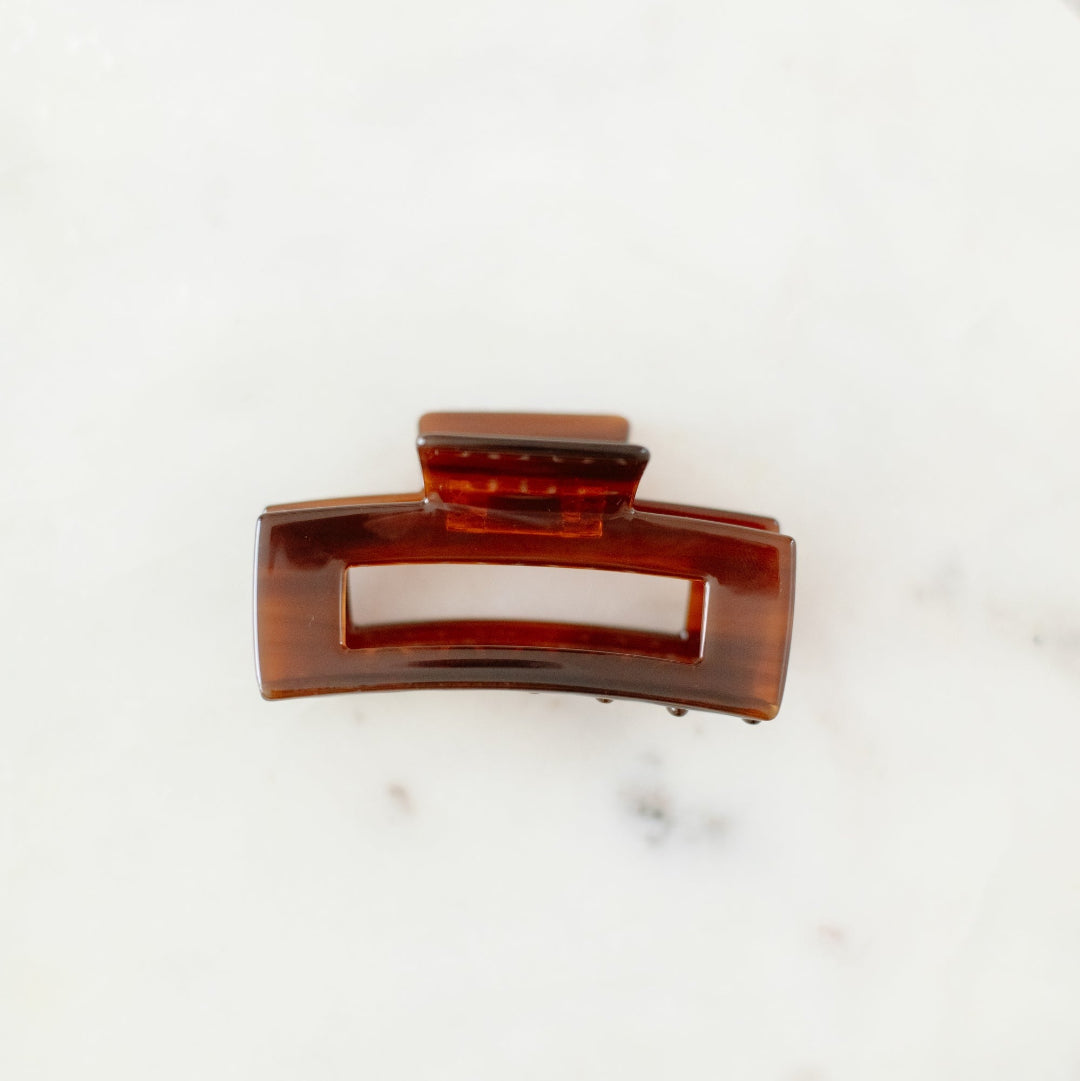 Brown hair clip on a white marble surface