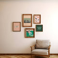 Framed artworks on a wall with a chair below