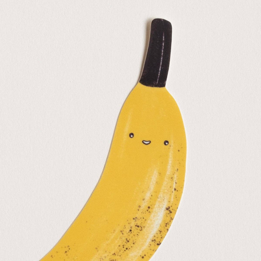 Yellow banana with a face on a white background