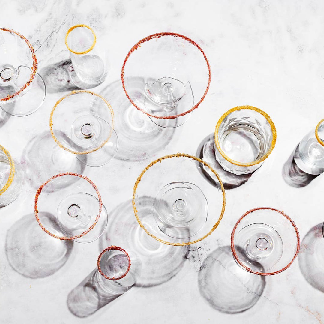 Clear glassware with gold and red accents on a light background