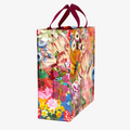 A reusable tote bag with a vibrant floral pattern. The bag features a variety of colorful flowers, including roses, lilies, and tulips, as well as a butterfly. The bag has dark red handles.