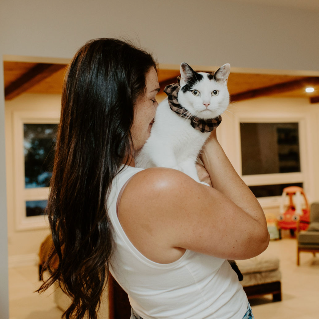 Woman holding a cat in a living room