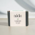 Bar of soap with 'aide' branding on a neutral background
