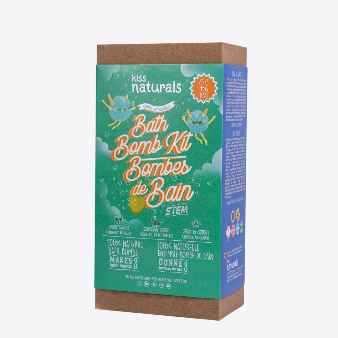 A cardboard box containing a Kiss Naturals Bath Bomb Kit. The box is green and white with the product name and a colorful illustration of bath bombs. It states that the kit is 100% natural, made in Canada, and suitable for ages 6 and up.