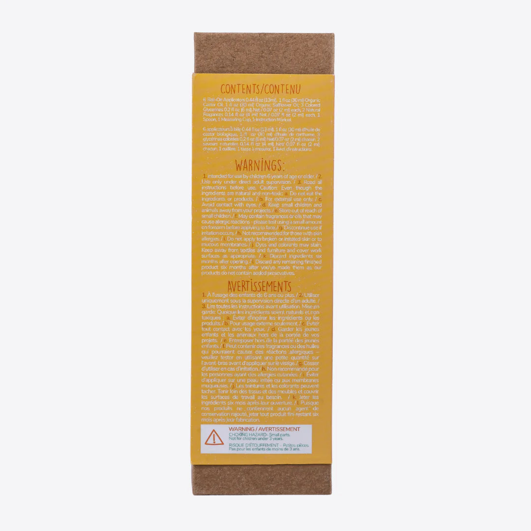 A cardboard box containing a Kiss Naturals Lava Lip Gloss Kit. The box is orange and white with the product name and a colorful illustration of a dragon. It states that the kit is 100% natural, made in Canada, and suitable for ages 6 and up.