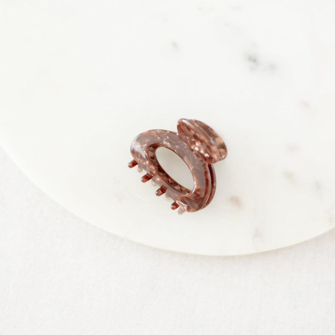 Rose gold hair clip on a white surface