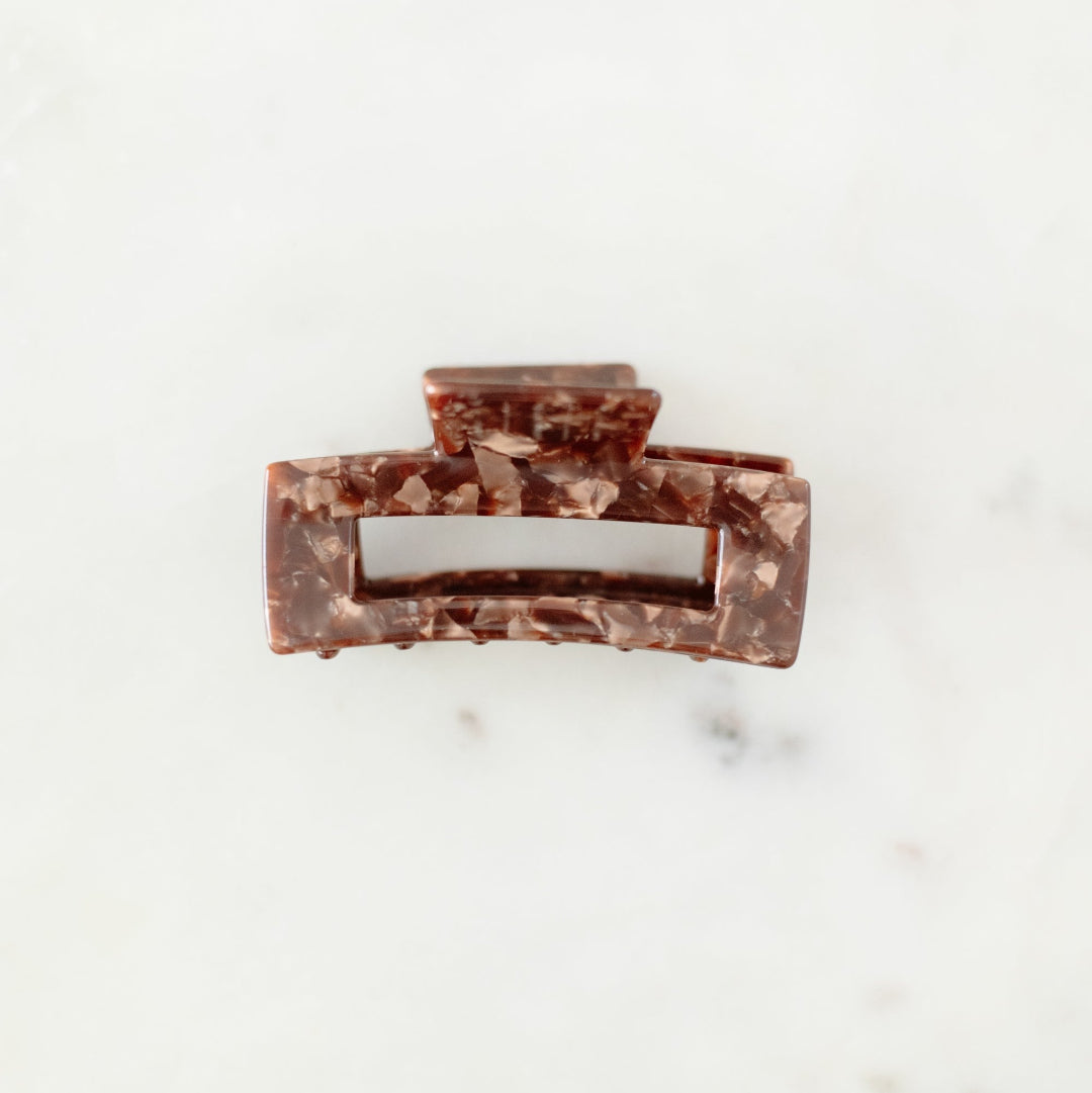 Marble-patterned hair clip on a marble surface