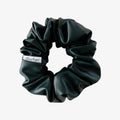 Black scrunchie with a brand label on a white background