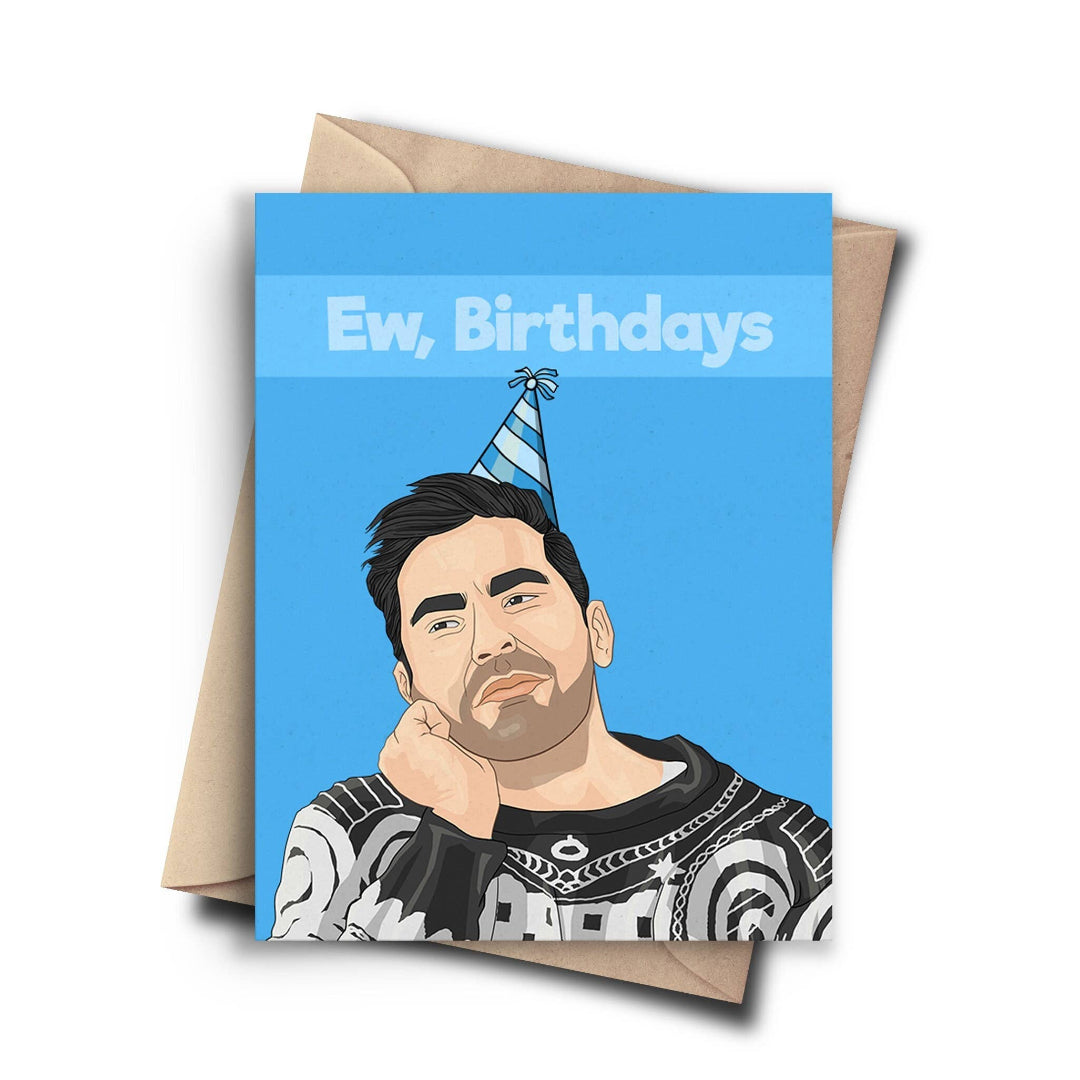 A birthday card with a cartoon image of David Rose from Schitt's Creek, wearing a party hat and a bored expression, with his head in his hand. The text on the blue background reads "Ew, Birthdays." A brown kraft envelope is behind the card.