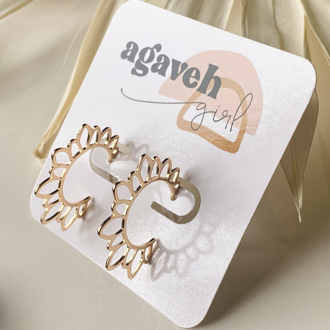 Gold sun-shaped earrings on a 'agaveh girl' branded card.