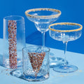 Set of glassware with decorative rims on a blue background