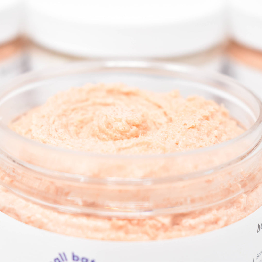 Jar of peach-colored cream with a blurred background