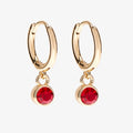 A set of three pairs of ruby earrings displayed on a red card. The set includes a pair of stud earrings, a pair of bar earrings with small ruby beads, and a pair of hoop earrings with dangling ruby stones. The card has the month "July" and the brand name "Foxy Originals."