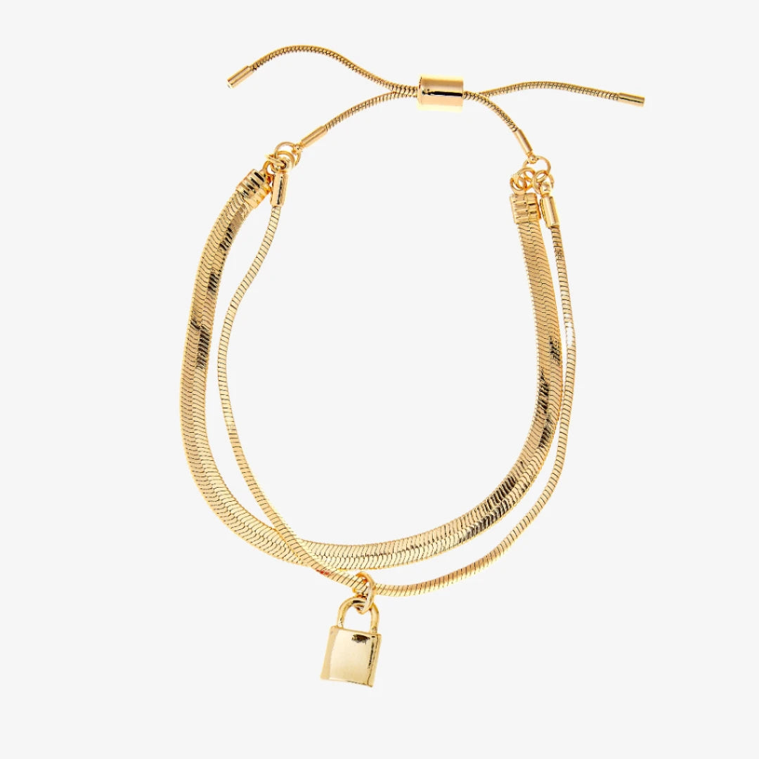 A gold layered bracelet with a small padlock charm. The bracelet has two chains of different widths, and the padlock charm hangs from the thinner chain.