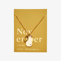 A gold necklace with a citrine stone pendant. The pendant also has the word "JOY" engraved on it. The necklace is displayed on a yellow card with the month "November" and the brand name "Foxy Originals."