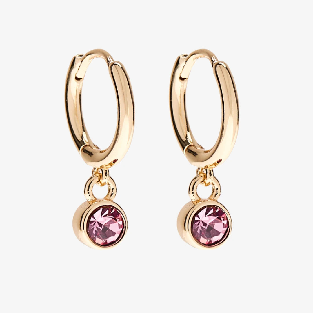 A set of three pairs of opal earrings displayed on a pink card. The set includes a pair of stud earrings, a pair of bar earrings with small opal beads, and a pair of hoop earrings with dangling opal stones. The card has the month "October" and the brand name "Foxy Originals."