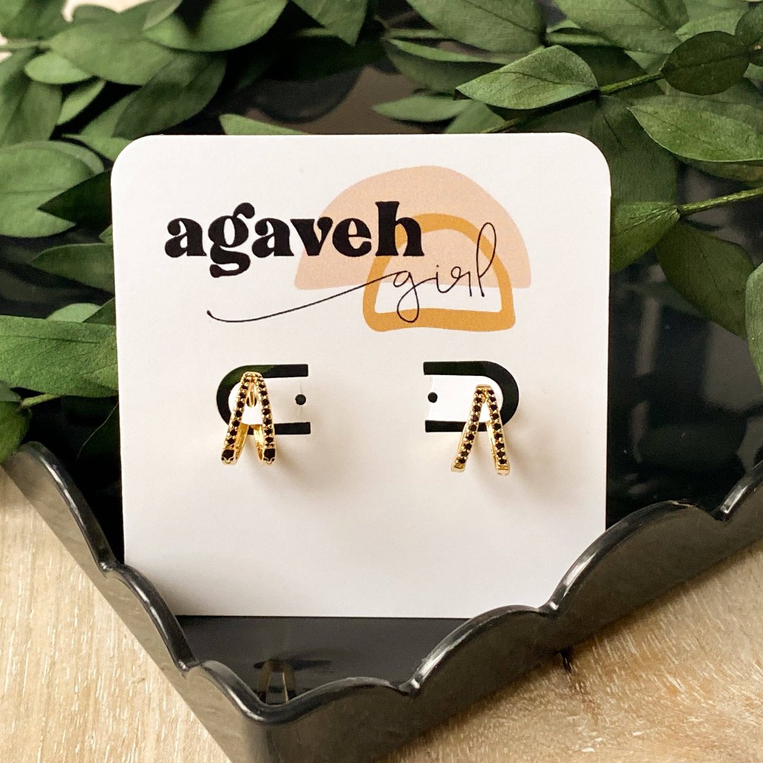 A pair of gold hoop earrings with black beading.