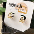 A pair of gold hoop earrings with black beading.