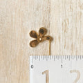 A pair of Agaveh Girl gold Forget Me Not Earrings, featuring a small, gold flower design with a beige center, displayed on a branded card with the text 'agaveh girl,' against a textured background with white floral accents. The earrings are dainty and floral, available in Ottawa, Ontario, Canada.