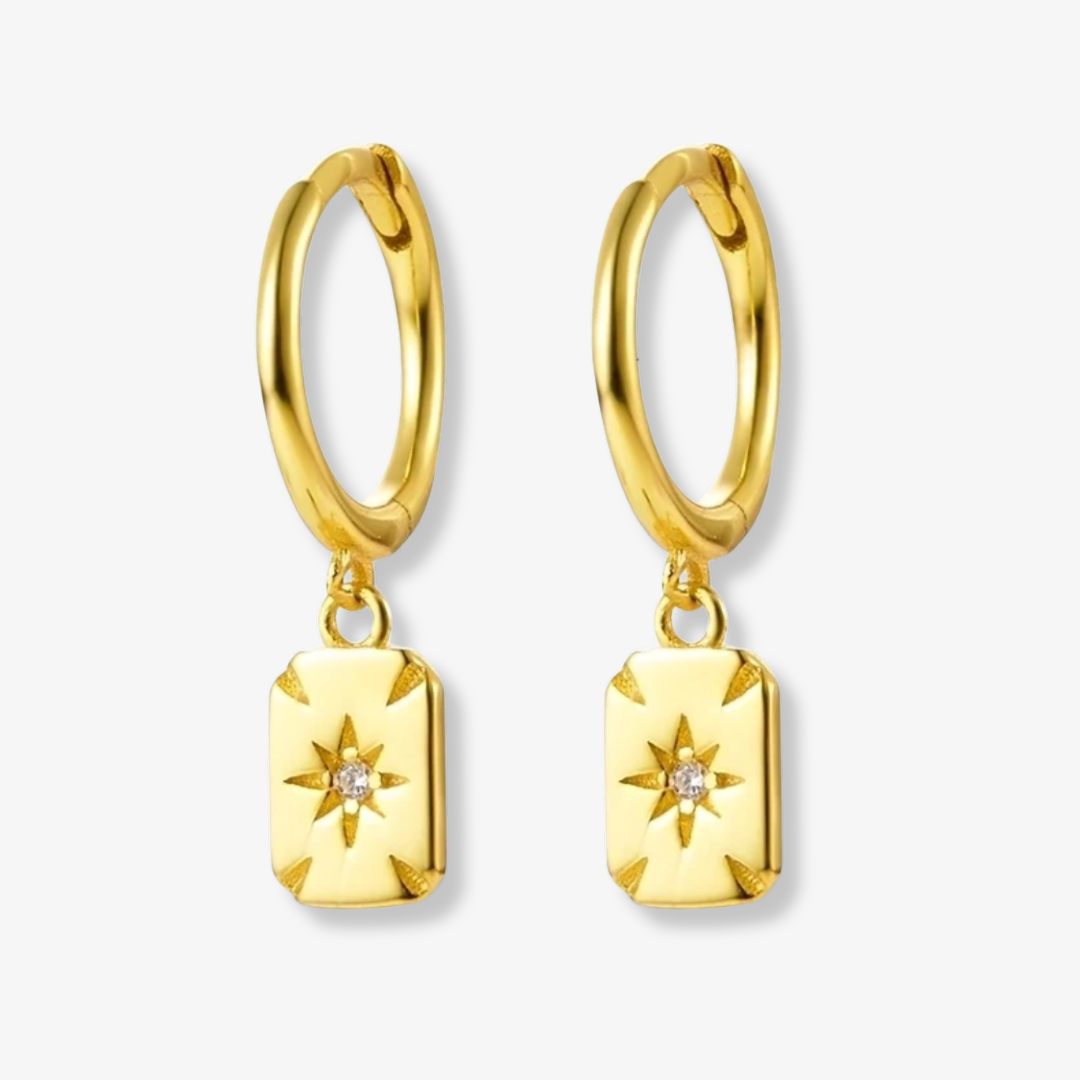 Gold plated rectangle drop earrings, potentially Bohomoon style, featuring small gold hoops with dangling rectangular charms, each with a central starburst design and a sparkling crystal. These modern earrings are available in Ottawa, Ontario, Canada.
