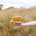 Hand holding a stack of folded fabric in a field
