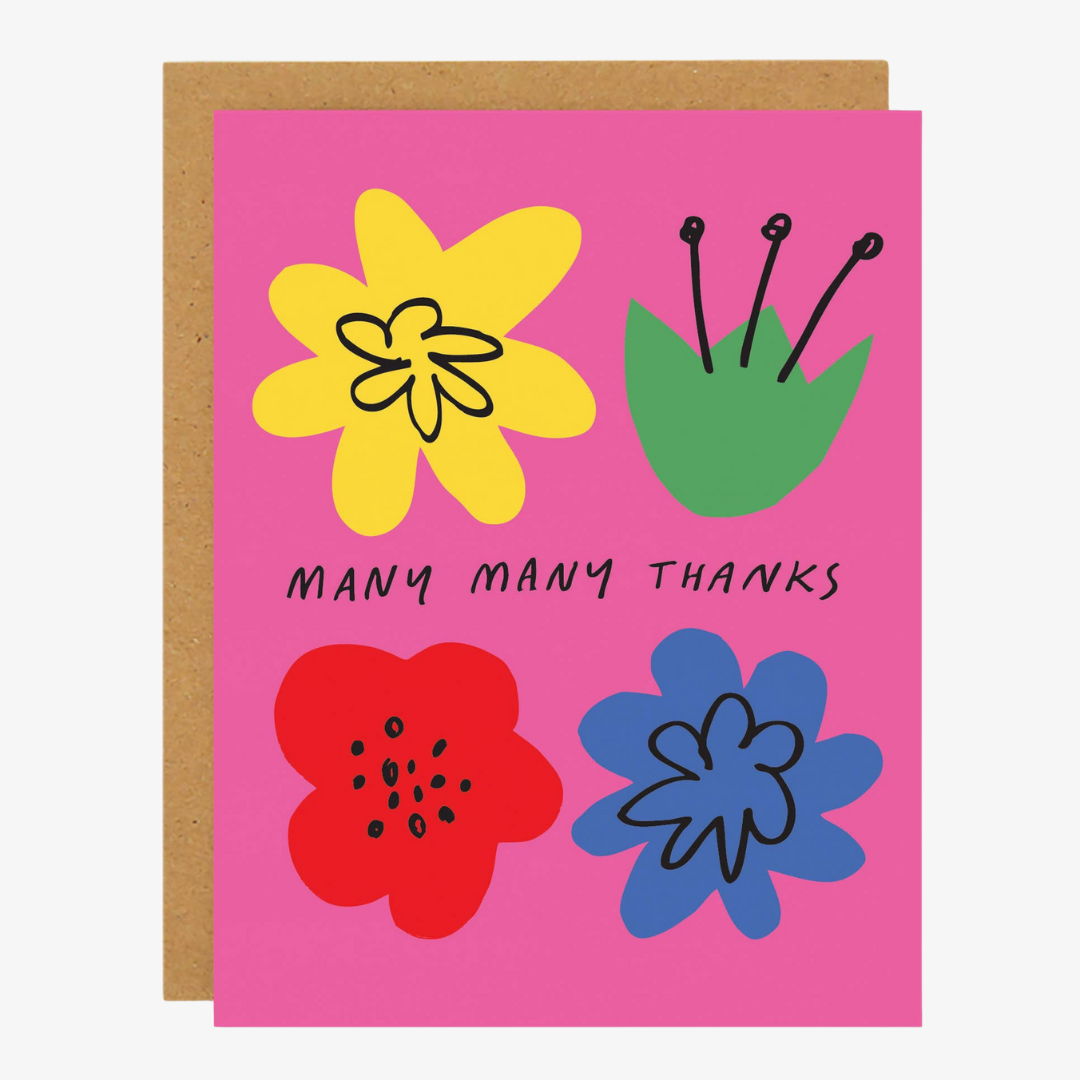 A pink greeting card with a brown envelope. The card features four colorful flowers in yellow, green, red, and blue, along with the text "MANY MANY THANKS" in black.