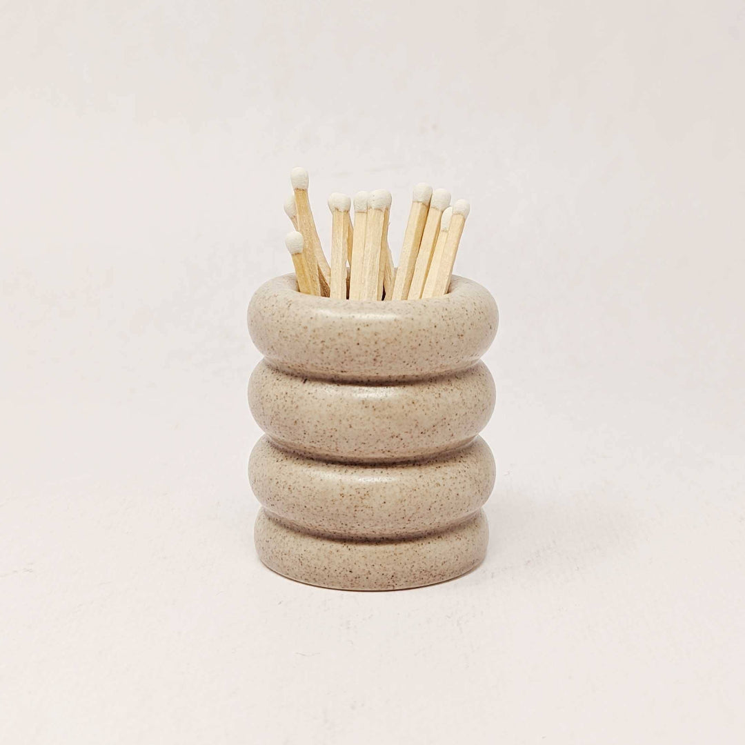 Stacked ceramic rings with wooden sticks on a light background