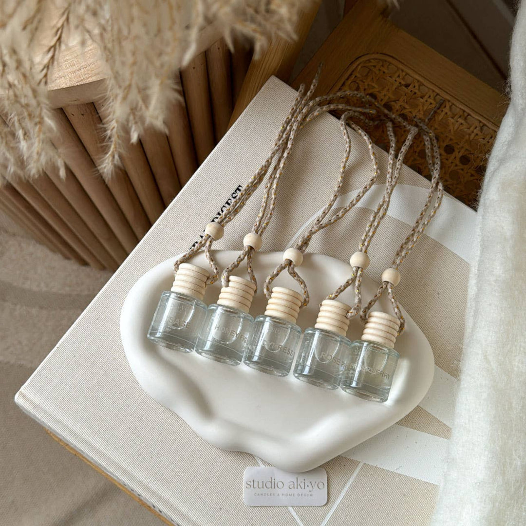 Set of small glass bottles with wooden caps on a white dish, with 'studio addyo' branding.