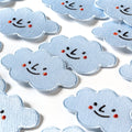 Collection of cloud-shaped patches with smiley faces on a white background