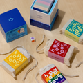 Happy Tears conversation cards, Ottawa. Inclusive card game for meaningful connections. Grey drawstring bag, multicoloured rainbow cards. Fun queer card game.