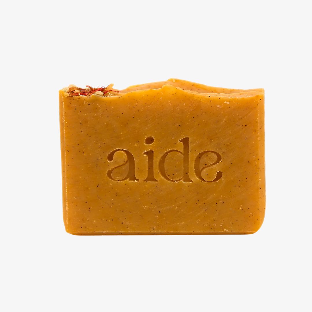 Bar of orange soap with 'aide' branding on a white background
