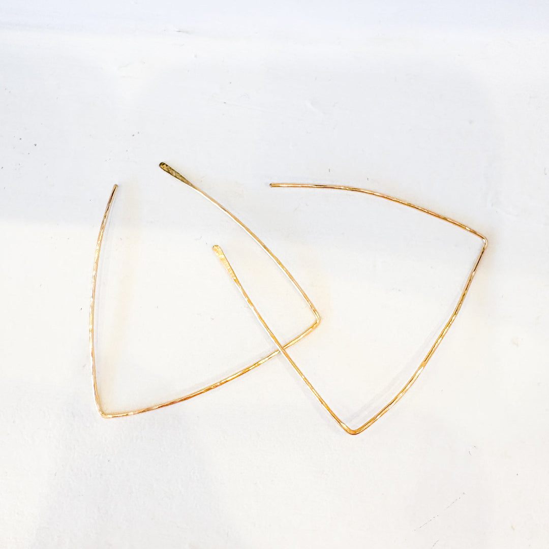 Gold triangle-shaped earrings on a white background