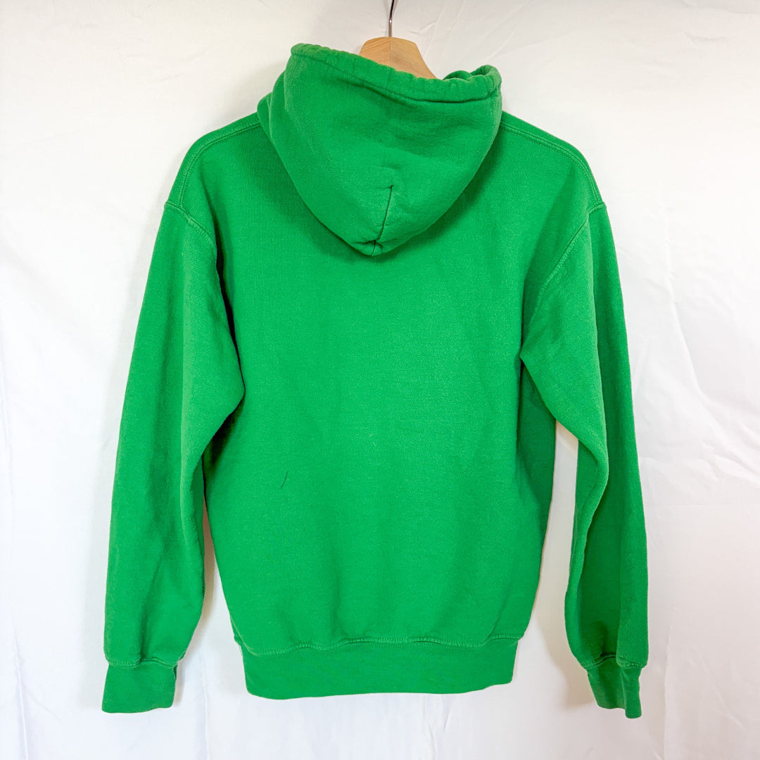 The back view of the same green Gildan hoodie, hanging on a wooden hanger against a white background. The back is plain.