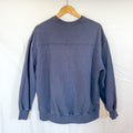 The back view of the same navy blue crewneck sweatshirt, hanging on a wooden hanger against a white background.
