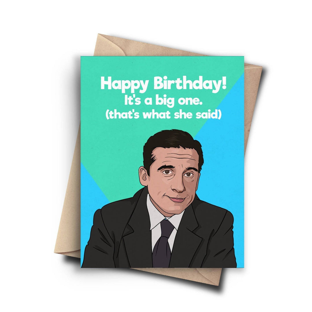 A humorous birthday card with a cartoon image of Michael Scott from The Office. The text on the card reads, "Happy Birthday! It's a big one. (that's what she said)". A brown kraft envelope is behind the card.