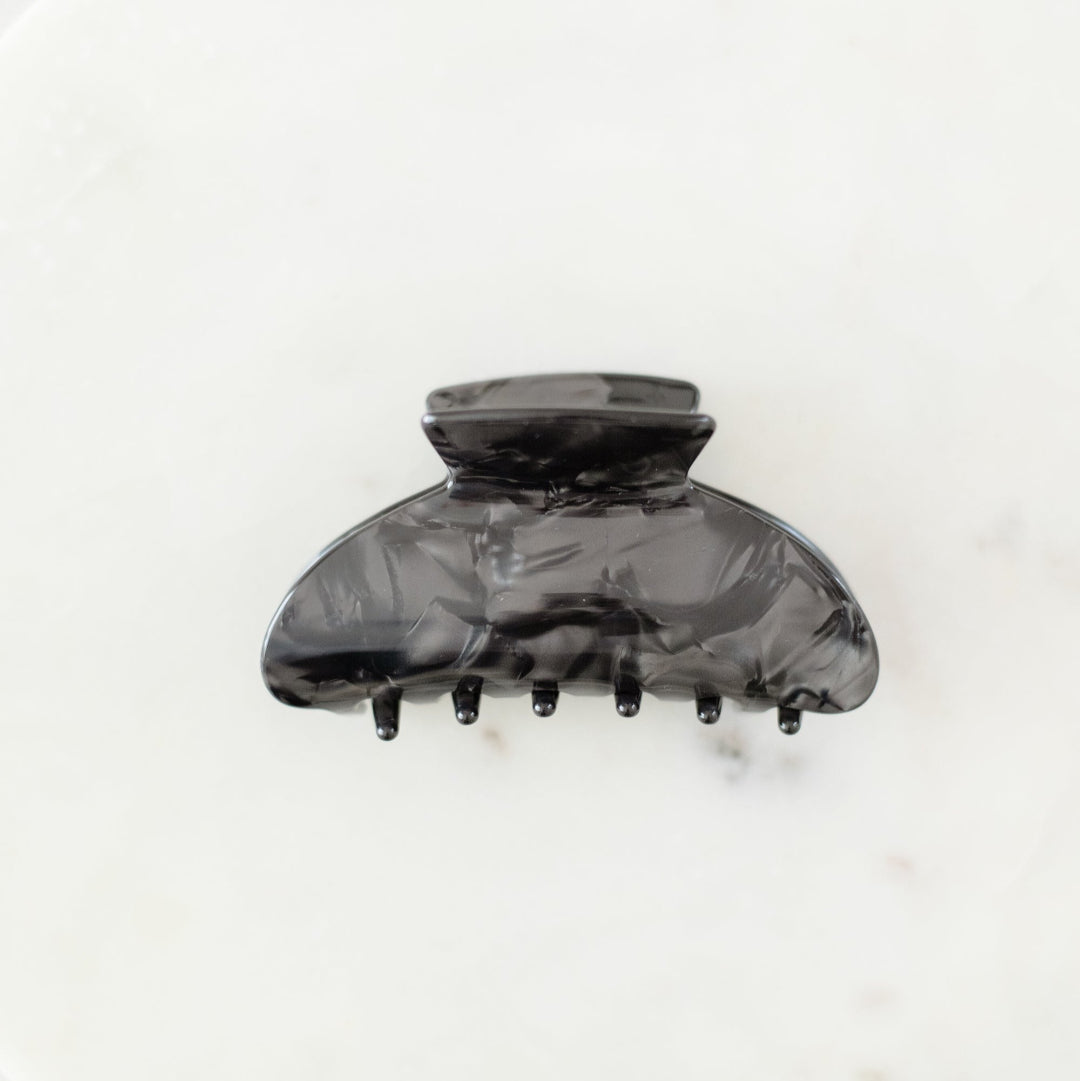 Black marbled hair clip on a white background