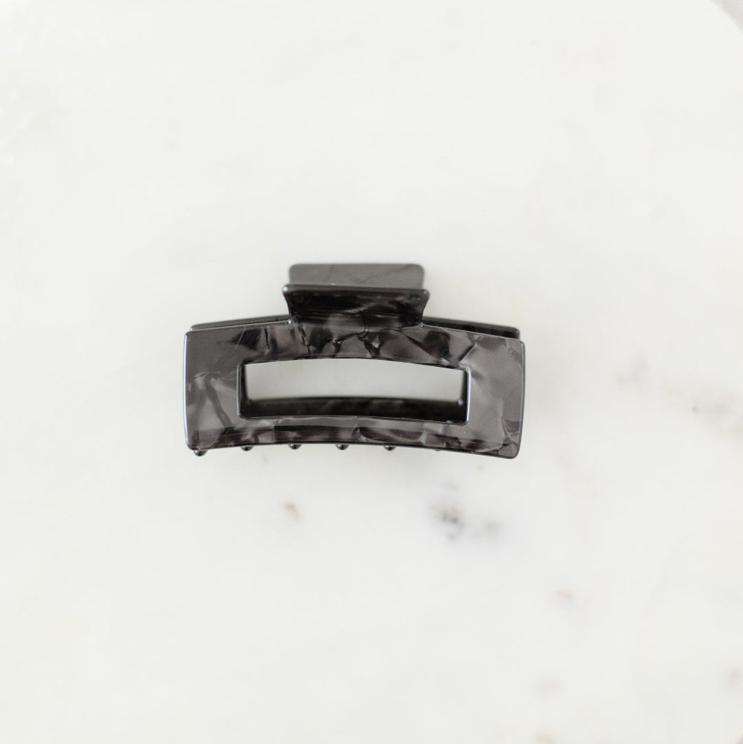 Black hair clip on a marble surface