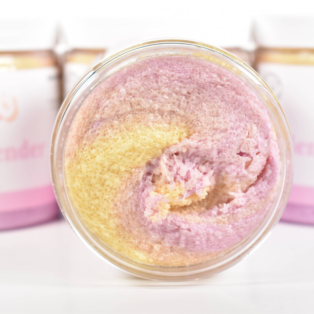 Bath scrub in a glass container with pink and yellow colors, surrounded by jars labeled 'Bath & Body Works'.