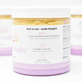 Jar of lavender body scrub with label on a white background