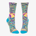 A pair of grey women's crew socks with vibrant, abstract floral and swirling line patterns in purple, yellow, pink, green, and blue. Text on one sock reads "I LOVE MY ASSHOLE KIDS".