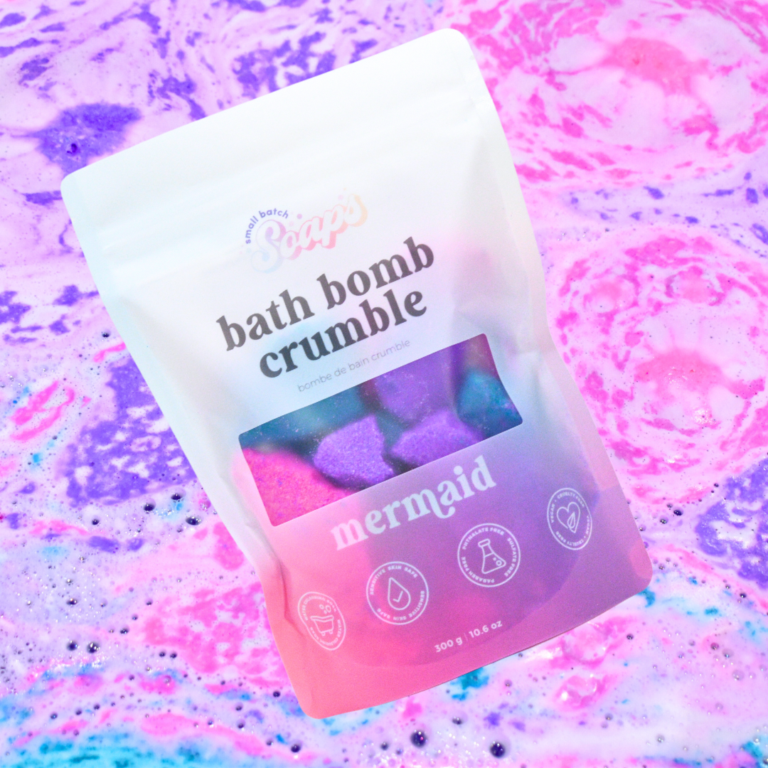Bath bomb crumble packaging with 'mermaid' theme on a colorful, textured background