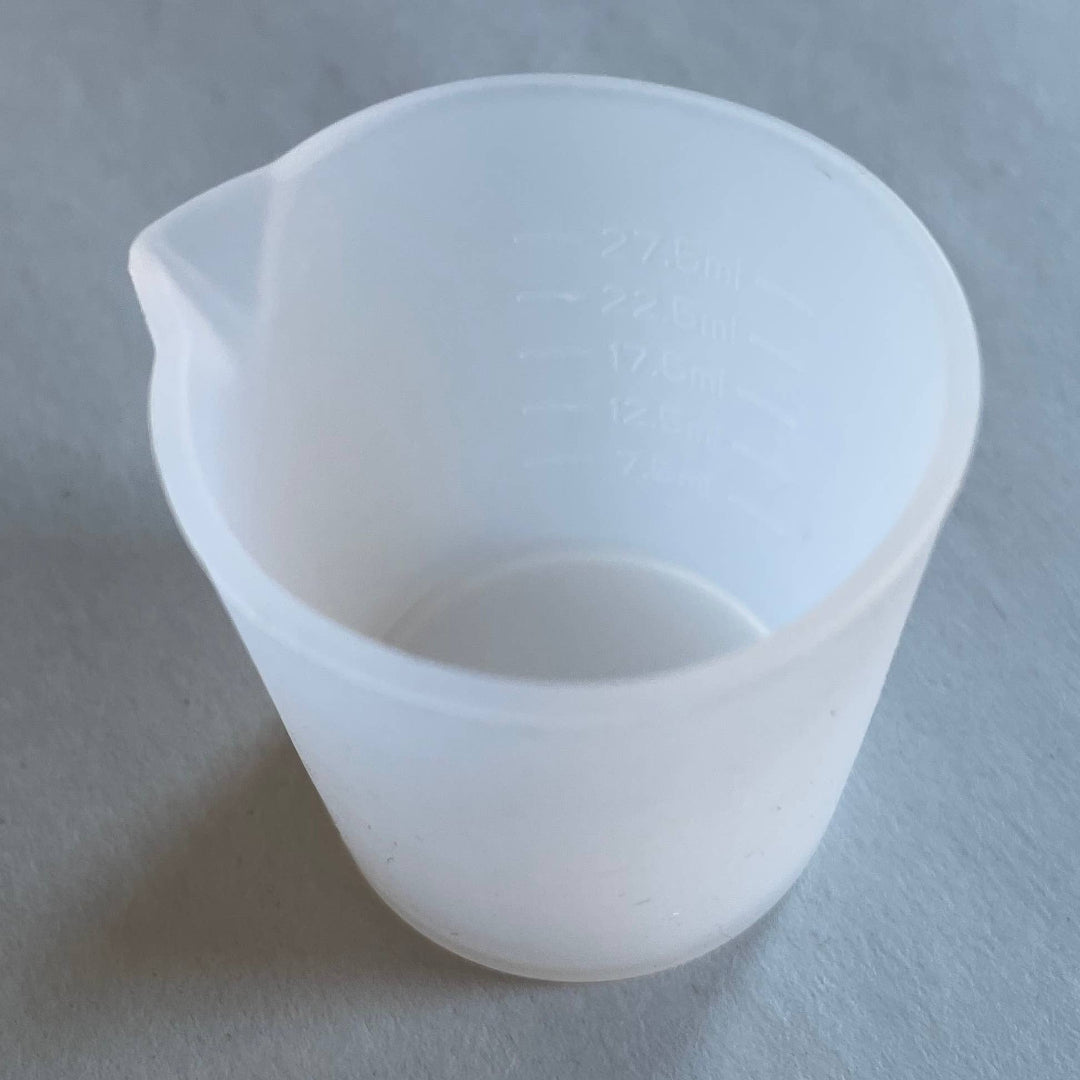 White plastic beaker on a gray background