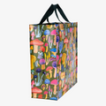 A reusable tote bag with a mushroom pattern. The bag is olive green with black handles. It is covered in a variety of colorful mushrooms in different shapes and sizes.
