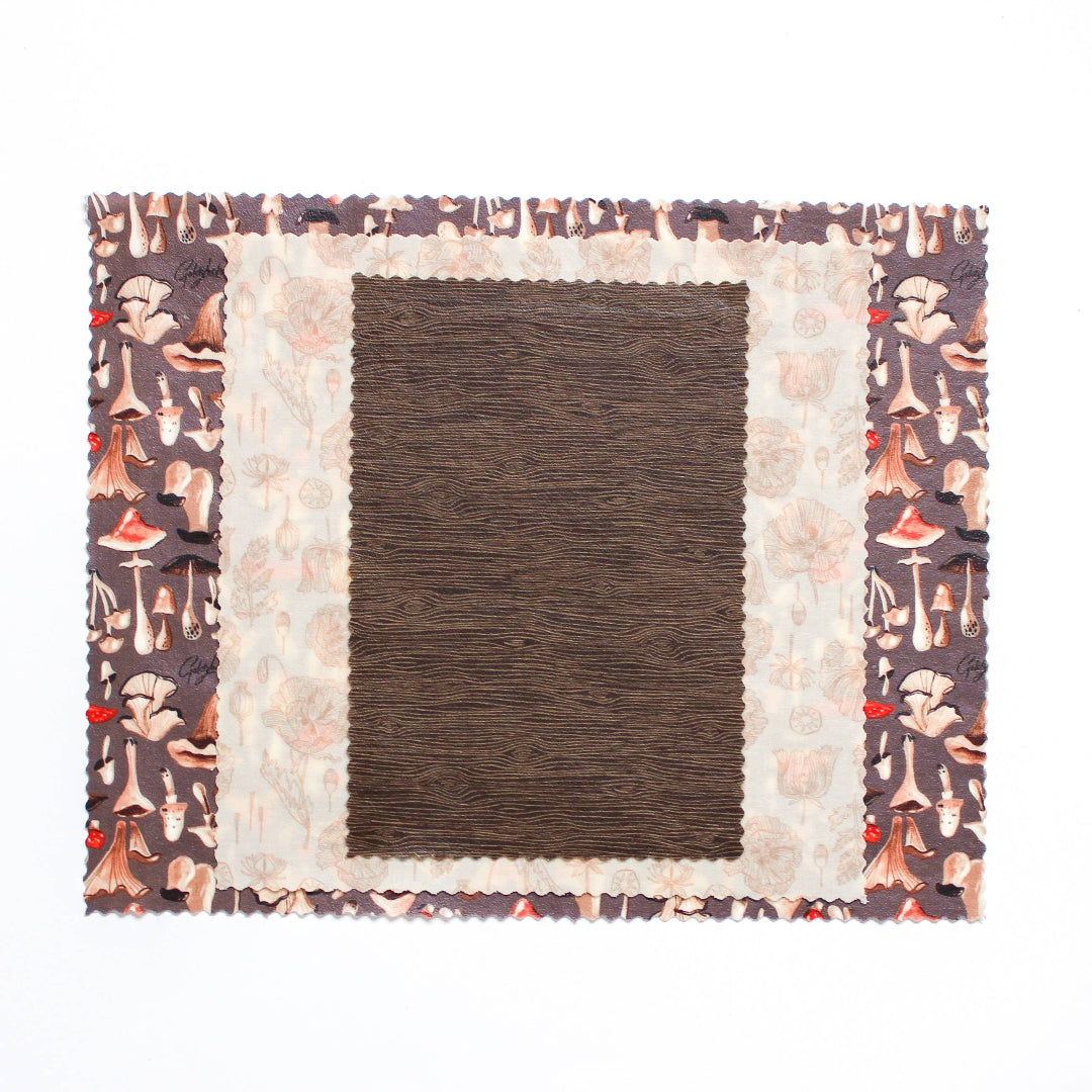 Decorative quilt with floral pattern border and brown square in center on white background