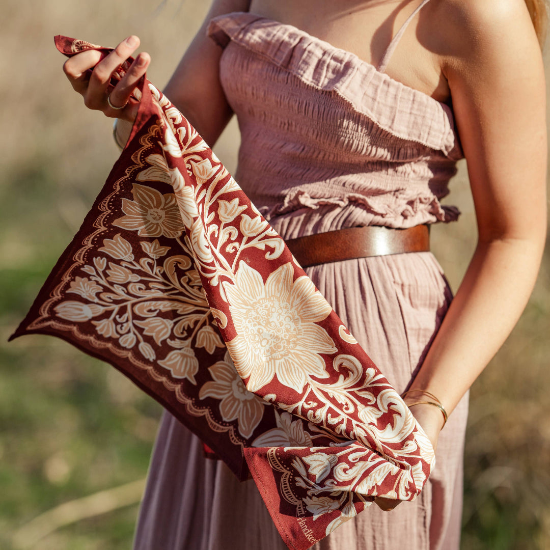 Woman holding a patterned scarf outdoors