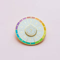 A circular pin with a colorful wheel featuring numbers from 0 to 9. The phrase "And the Numbers" is written in the center.