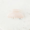 Pink hair clip on a white marble surface