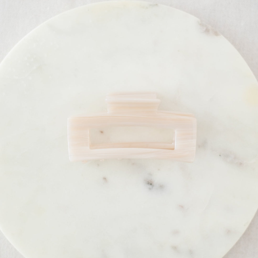 Pink hair clip on a marble surface